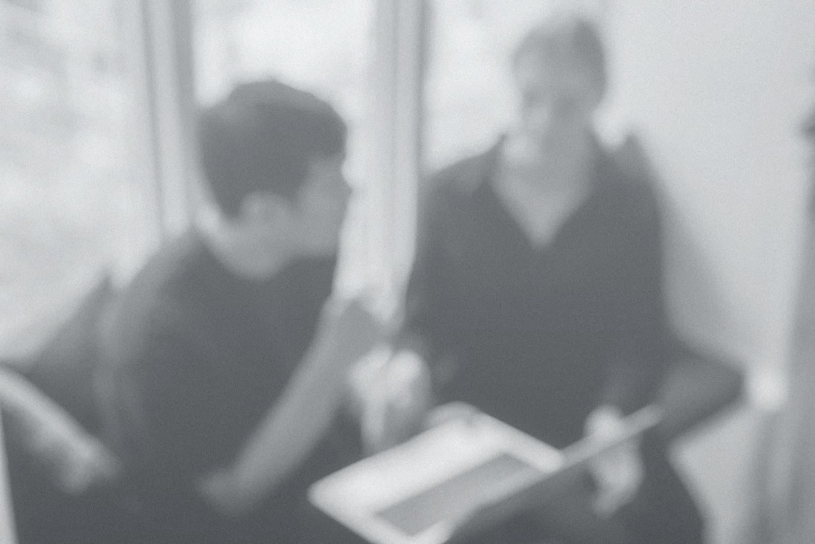 Two people reviewing work on a laptop in a workshop session